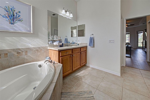 bathroom featuring tiled bath, ceiling fan, tile patterned floors, and vanity