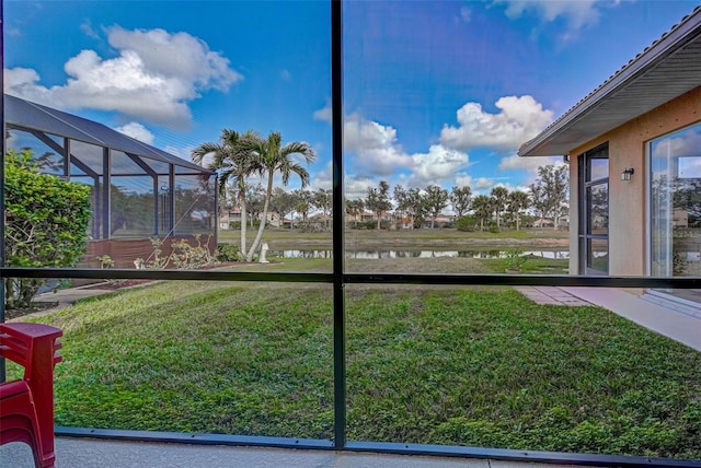 view of yard with a lanai and a water view