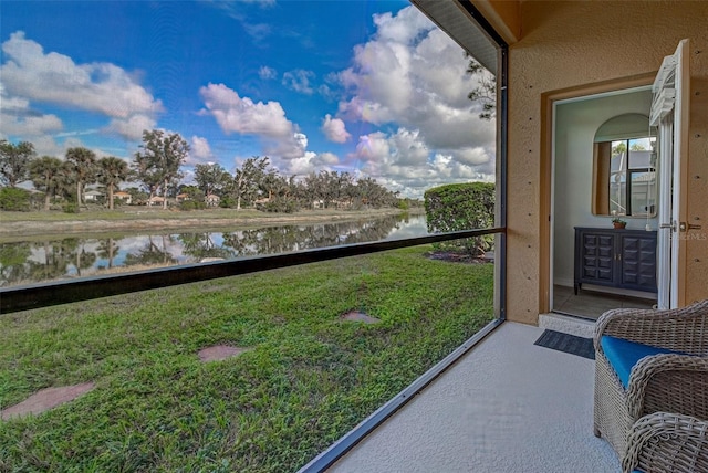 sunroom / solarium featuring a water view