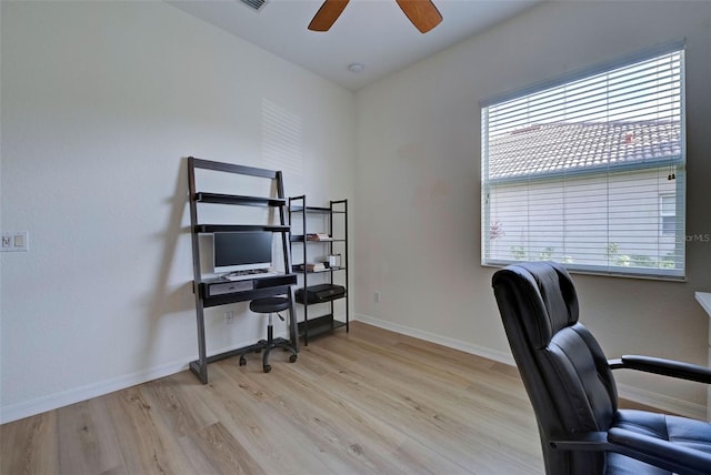 office space featuring light wood-type flooring, ceiling fan, and a healthy amount of sunlight