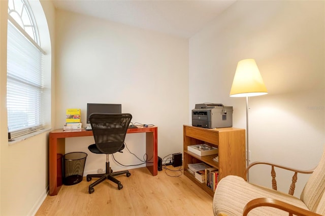 home office with light hardwood / wood-style floors and vaulted ceiling