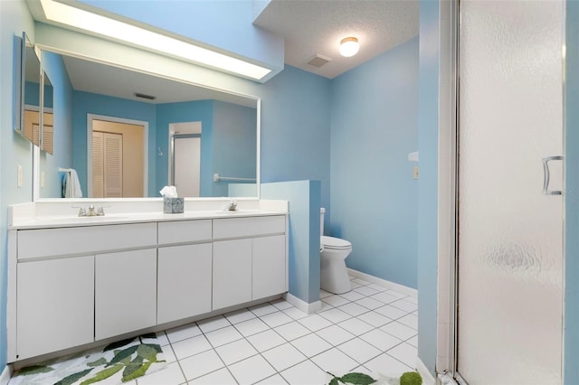 bathroom with tile patterned flooring, a textured ceiling, vanity, and a shower with door