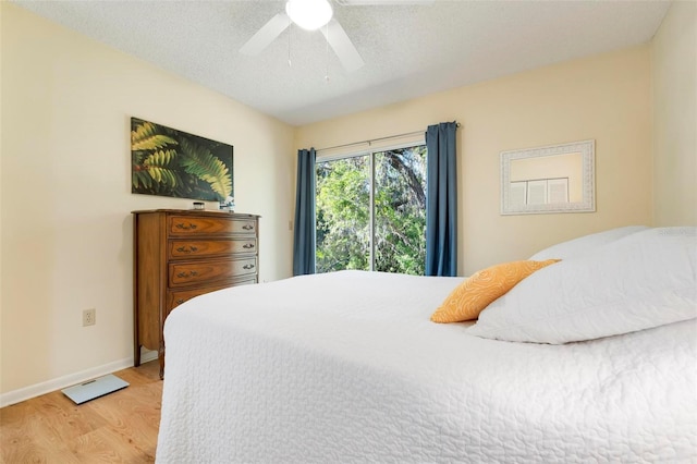 bedroom featuring ceiling fan, a textured ceiling, and hardwood / wood-style flooring