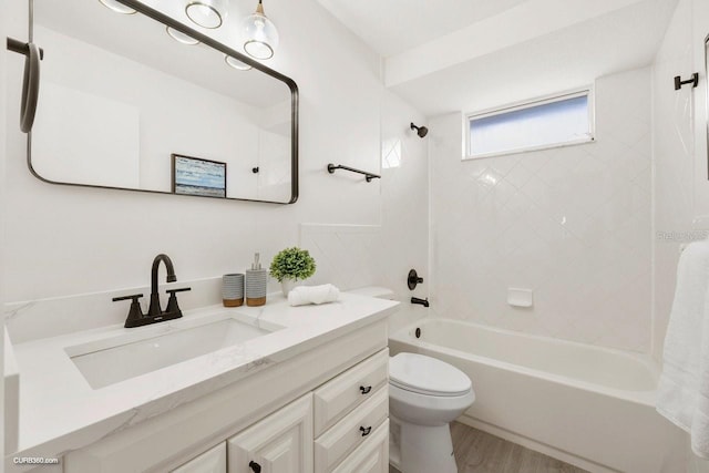 full bathroom with toilet, hardwood / wood-style floors, vanity, and tiled shower / bath