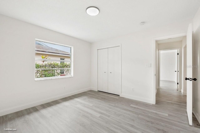 unfurnished bedroom featuring a closet and light hardwood / wood-style floors