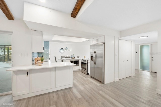 kitchen with stainless steel appliances, beamed ceiling, kitchen peninsula, light hardwood / wood-style floors, and white cabinets