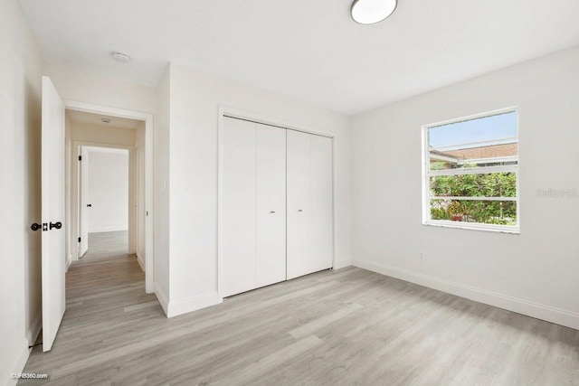 unfurnished bedroom featuring light hardwood / wood-style floors and a closet