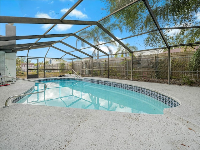 view of swimming pool featuring glass enclosure and a patio area