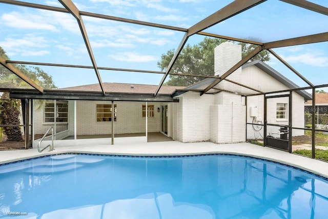 view of pool featuring glass enclosure and a patio area