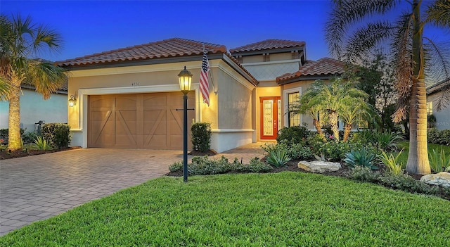 mediterranean / spanish-style house featuring a front yard and a garage