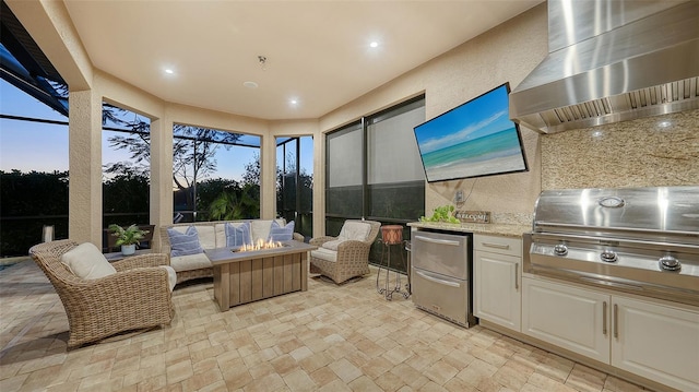 view of patio / terrace with an outdoor kitchen, a lanai, grilling area, and an outdoor fire pit