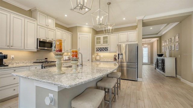 kitchen with stainless steel appliances, crown molding, light wood-style floors, and a sink