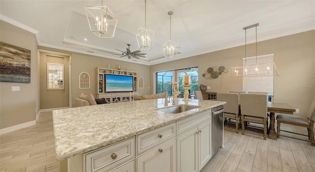 kitchen with stainless steel dishwasher, crown molding, open floor plan, and a sink