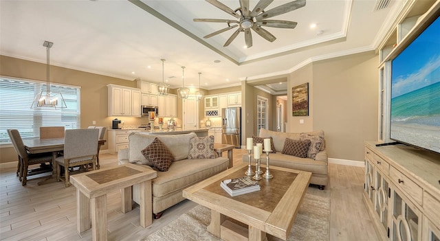 living room featuring light wood-type flooring, a raised ceiling, baseboards, and crown molding