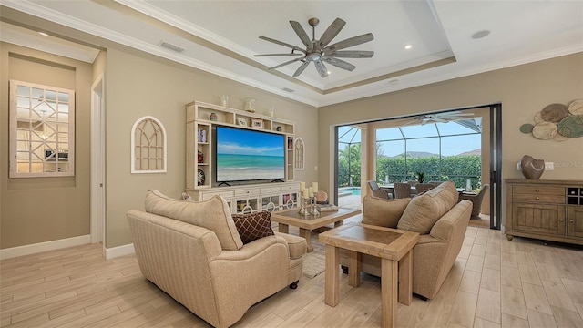 living area with baseboards, visible vents, light wood finished floors, ceiling fan, and ornamental molding