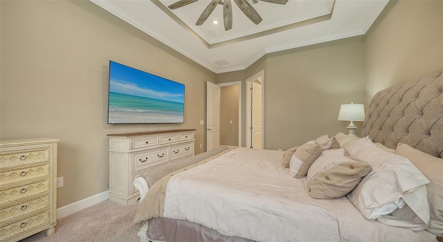 carpeted bedroom featuring ceiling fan, ornamental molding, and a tray ceiling