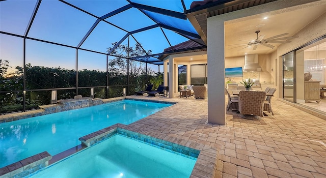 pool at dusk featuring a lanai, ceiling fan, and a patio