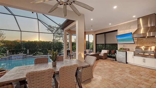 view of patio / terrace featuring glass enclosure, exterior kitchen, outdoor dining area, ceiling fan, and a grill