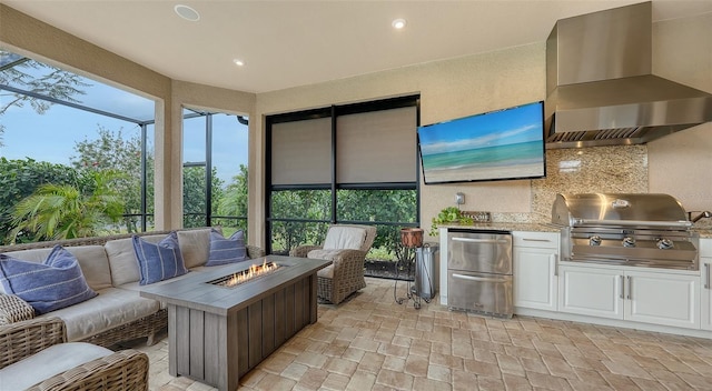 view of patio / terrace featuring a lanai, grilling area, an outdoor kitchen, and an outdoor living space with a fire pit