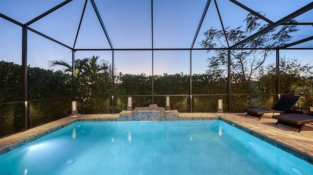 pool with glass enclosure and a patio