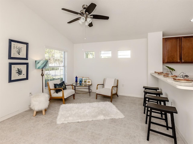 sitting room with ceiling fan, light tile patterned flooring, and lofted ceiling