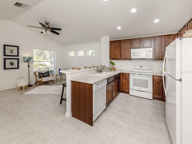 kitchen featuring white appliances, sink, vaulted ceiling, ceiling fan, and kitchen peninsula