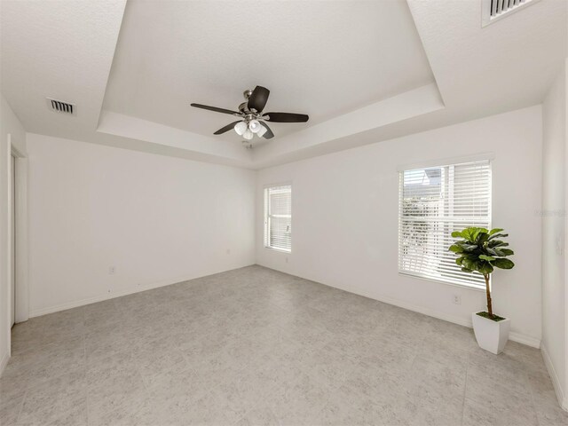 spare room featuring ceiling fan and a tray ceiling