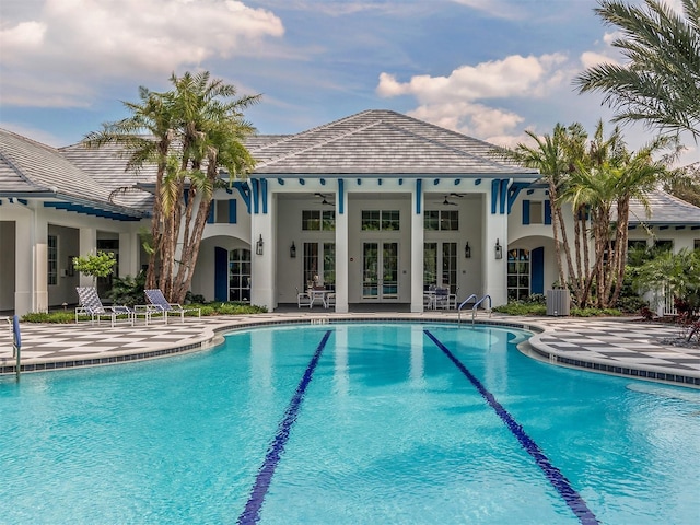 view of swimming pool featuring ceiling fan, french doors, and a patio