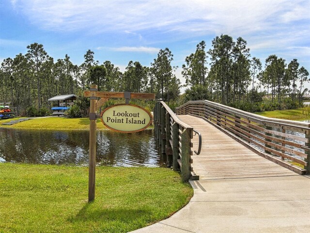 view of property's community featuring a lawn and a water view