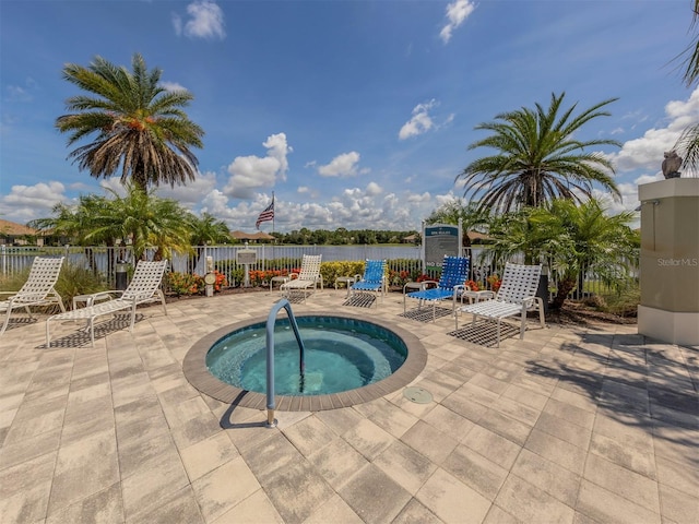 view of pool featuring a patio area, a community hot tub, and a water view