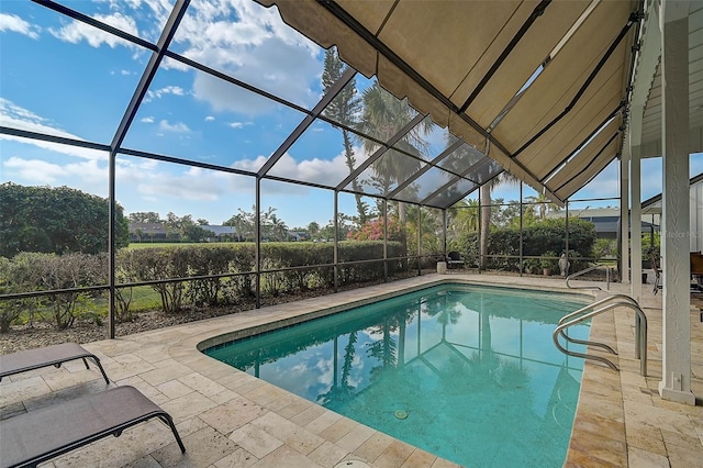 outdoor pool with glass enclosure and a patio area