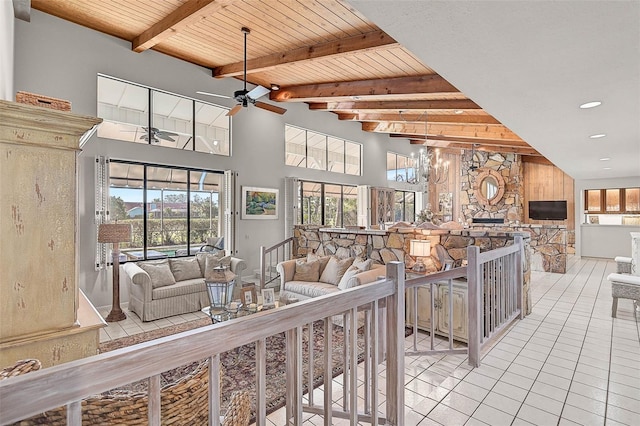 tiled living room featuring wooden ceiling, a high ceiling, ceiling fan, and beam ceiling