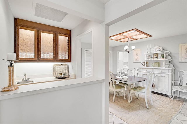 tiled dining space featuring a sink and a notable chandelier