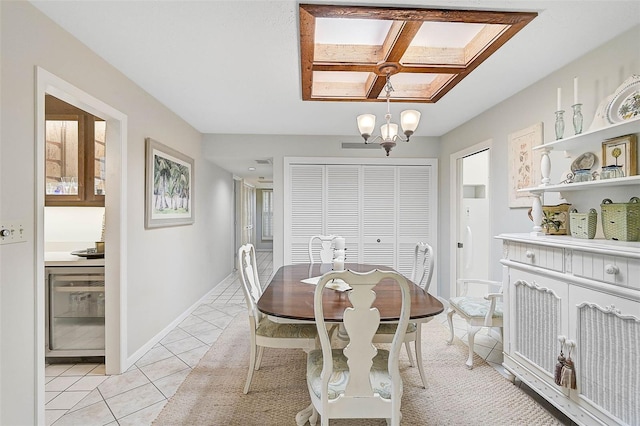 dining room with a chandelier, baseboards, and light tile patterned floors