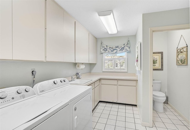 laundry room with light tile patterned floors, laundry area, washer and clothes dryer, a textured ceiling, and a sink