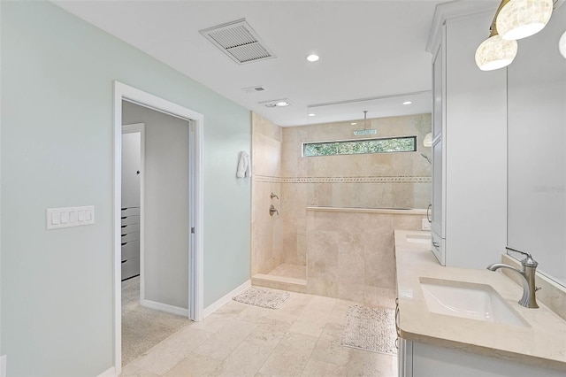 full bathroom with double vanity, visible vents, a sink, baseboards, and walk in shower