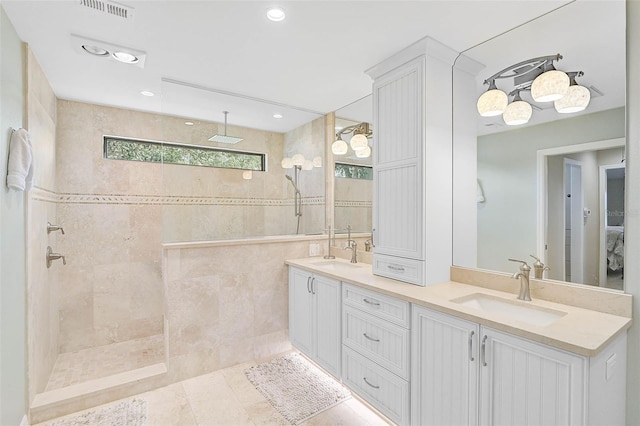 full bathroom featuring a walk in shower, a sink, and visible vents