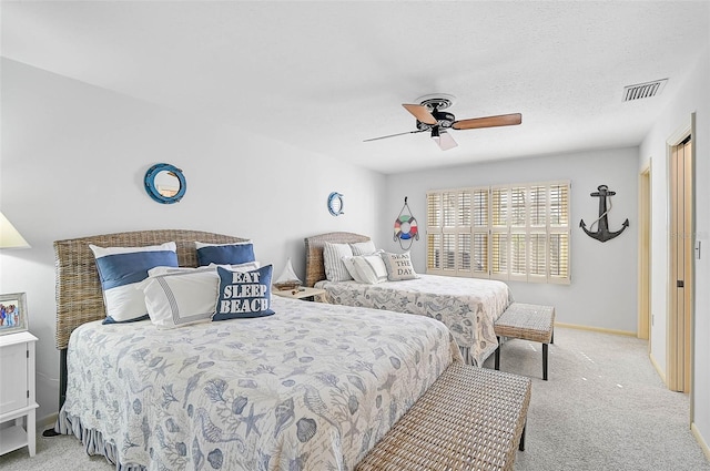 bedroom with ceiling fan, a textured ceiling, light colored carpet, visible vents, and baseboards