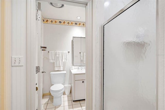 bathroom featuring toilet, a shower with shower door, vanity, and tile patterned floors