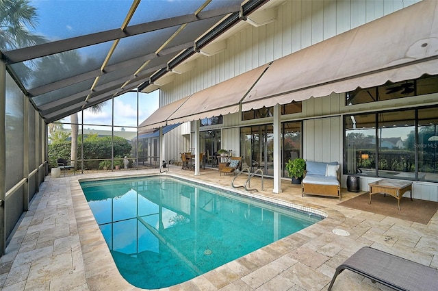 outdoor pool featuring glass enclosure and a patio