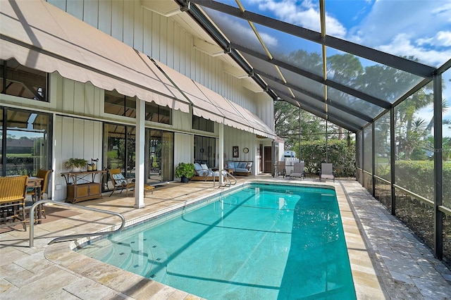 pool featuring glass enclosure and a patio area