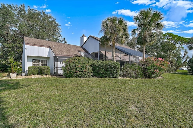 view of front facade featuring a chimney, a front yard, and a lanai