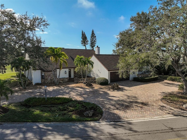 view of front of home with a garage, decorative driveway, and a chimney