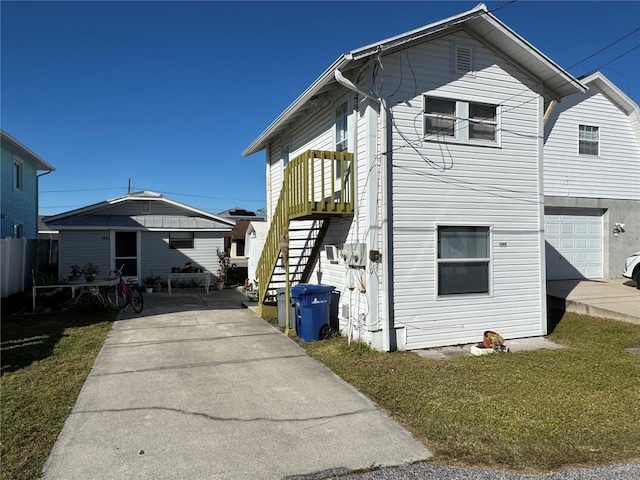 back of house featuring a lawn and a garage