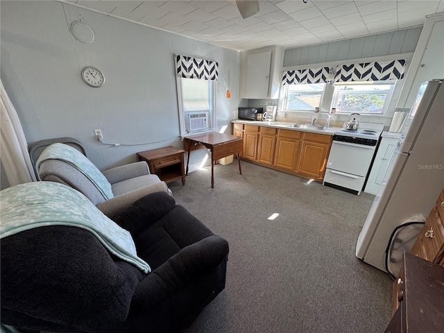 kitchen featuring white appliances, light colored carpet, cooling unit, and sink