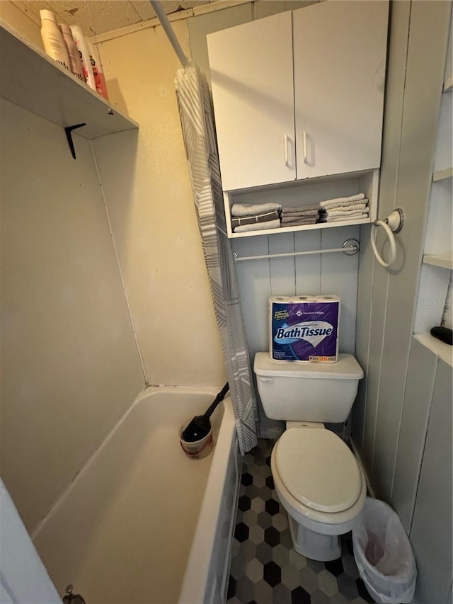 bathroom featuring shower / tub combo and toilet