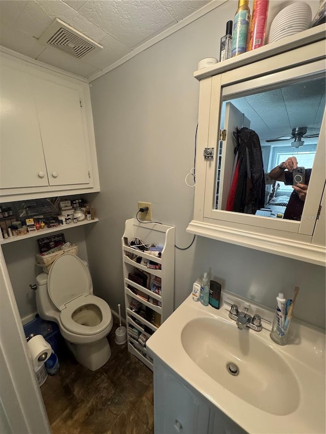 bathroom featuring vanity, ceiling fan, toilet, and a textured ceiling