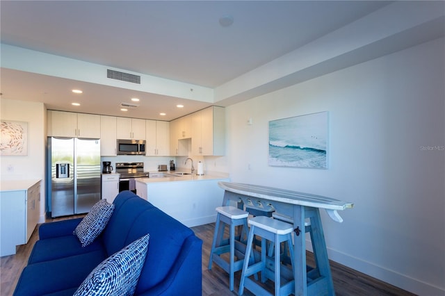 kitchen featuring white cabinetry, sink, dark wood-type flooring, and appliances with stainless steel finishes