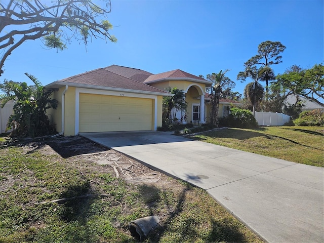 mediterranean / spanish-style home with a garage and a front lawn