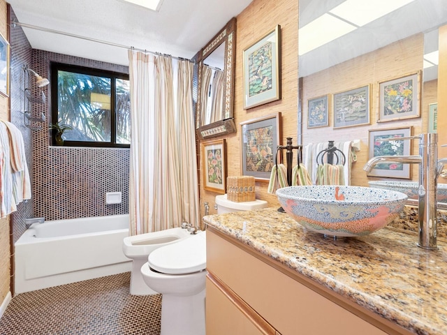 full bathroom with tile patterned flooring, a bidet, shower / bath combination with curtain, toilet, and vanity